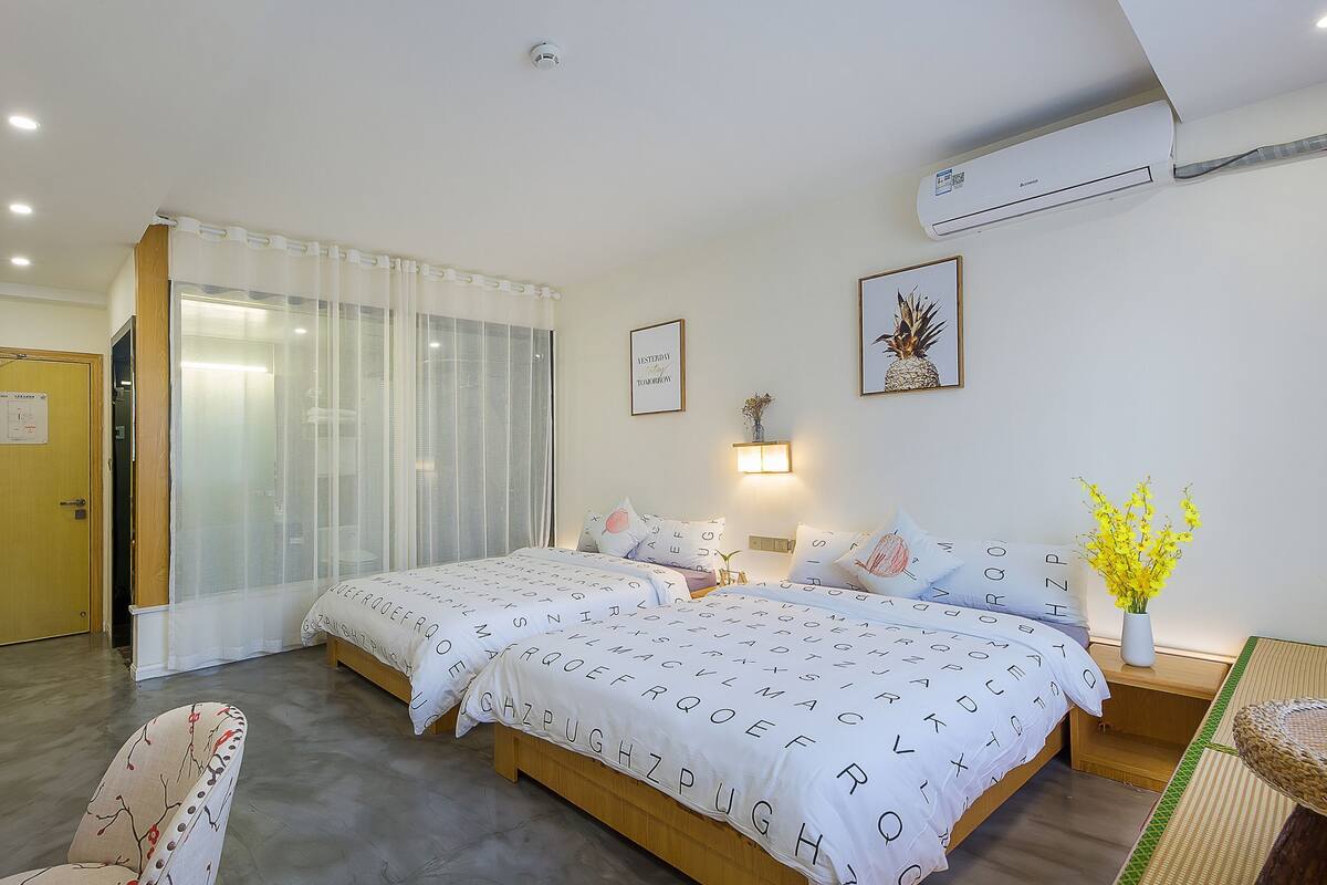 Habitación de hotel con una cama grande, un escritorio, una silla, zona de ducha y unidad de aire acondicionado.