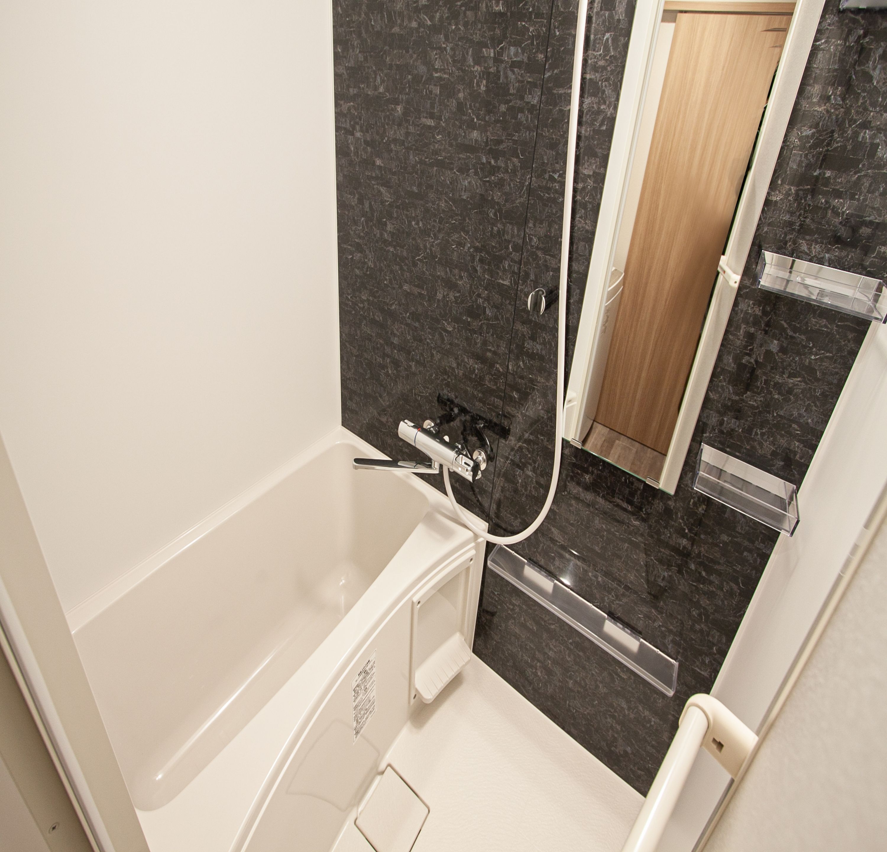 A modern bathroom with a bathtub, a shower, and a glass-enclosed vanity.