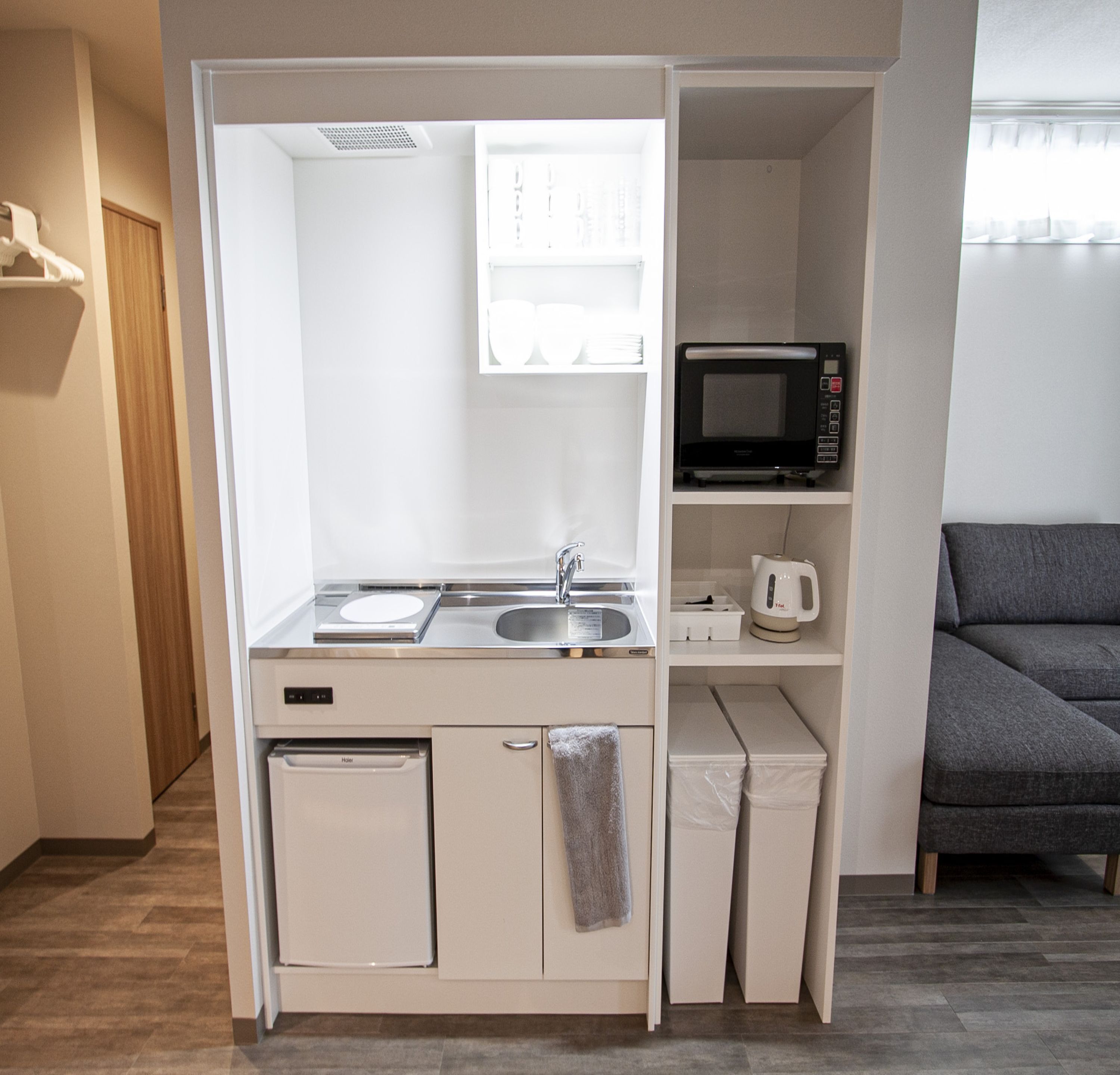 A compact kitchenette with a microwave, sink, and small refrigerator.