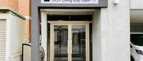 Entrada para UCHI Living Stay Odori 11, porta de vidro e uma placa acima.