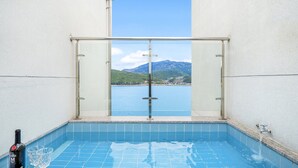 A pool with a clear view of a mountain and a body of water.