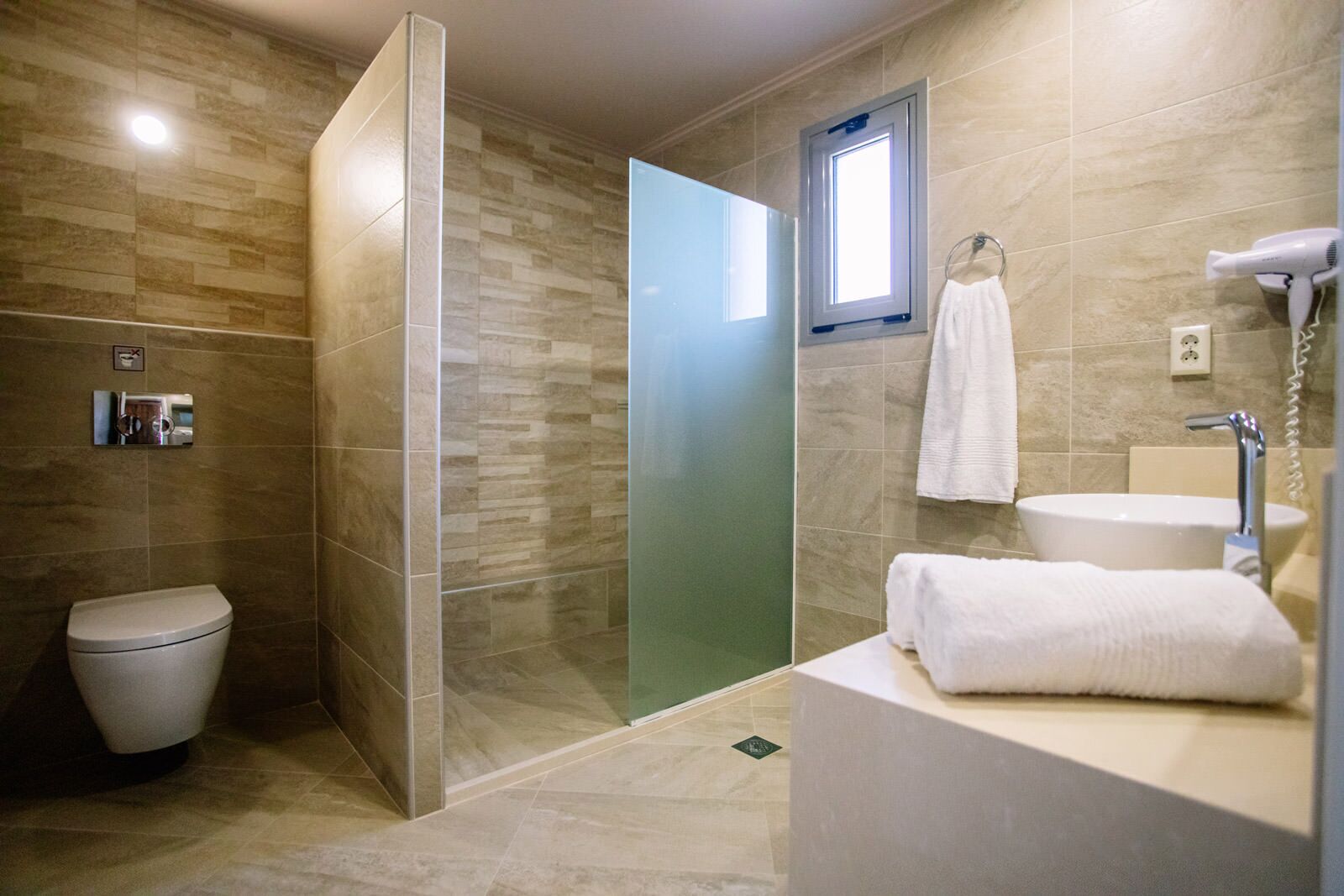 Ein modernes Badezimmer mit Toilette, Dusche und Waschbecken.