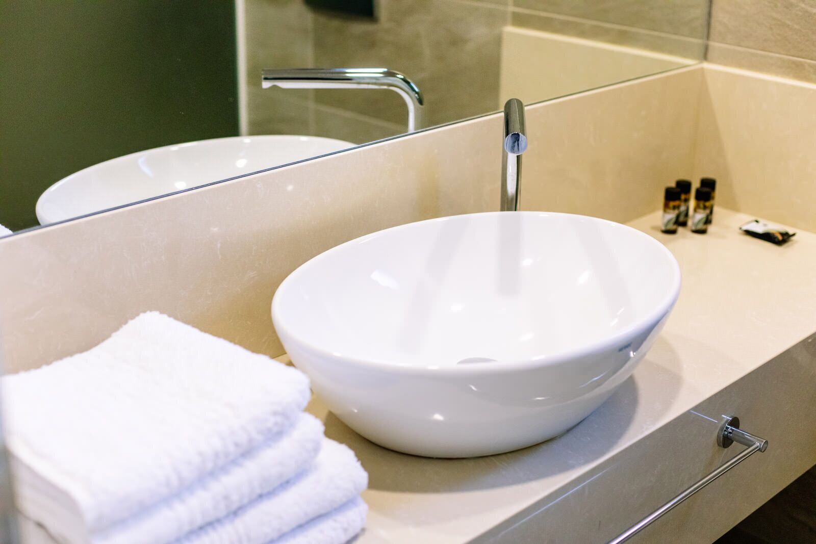 A bathroom with a white sink, a towel, and a glass shower enclosure.