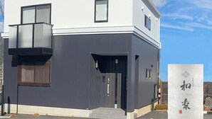 A modern two-story building with a white facade and dark grey accents. - Villas Waraku (Fujiyoshida)
