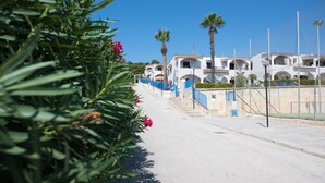 A coastal street with white buildings, palm trees, and a clear blue sky. - Holiday home in Sciacca Mare Tennis Soccer field, barbecue, wifi, kitchenette (Provincia di Agrigento)
