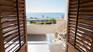A balcony with a glass table, a chair, and a decorative item. - Holiday home in Sciacca Mare Tennis Soccer field, barbecue, wifi, kitchenette (Provincia di Agrigento)