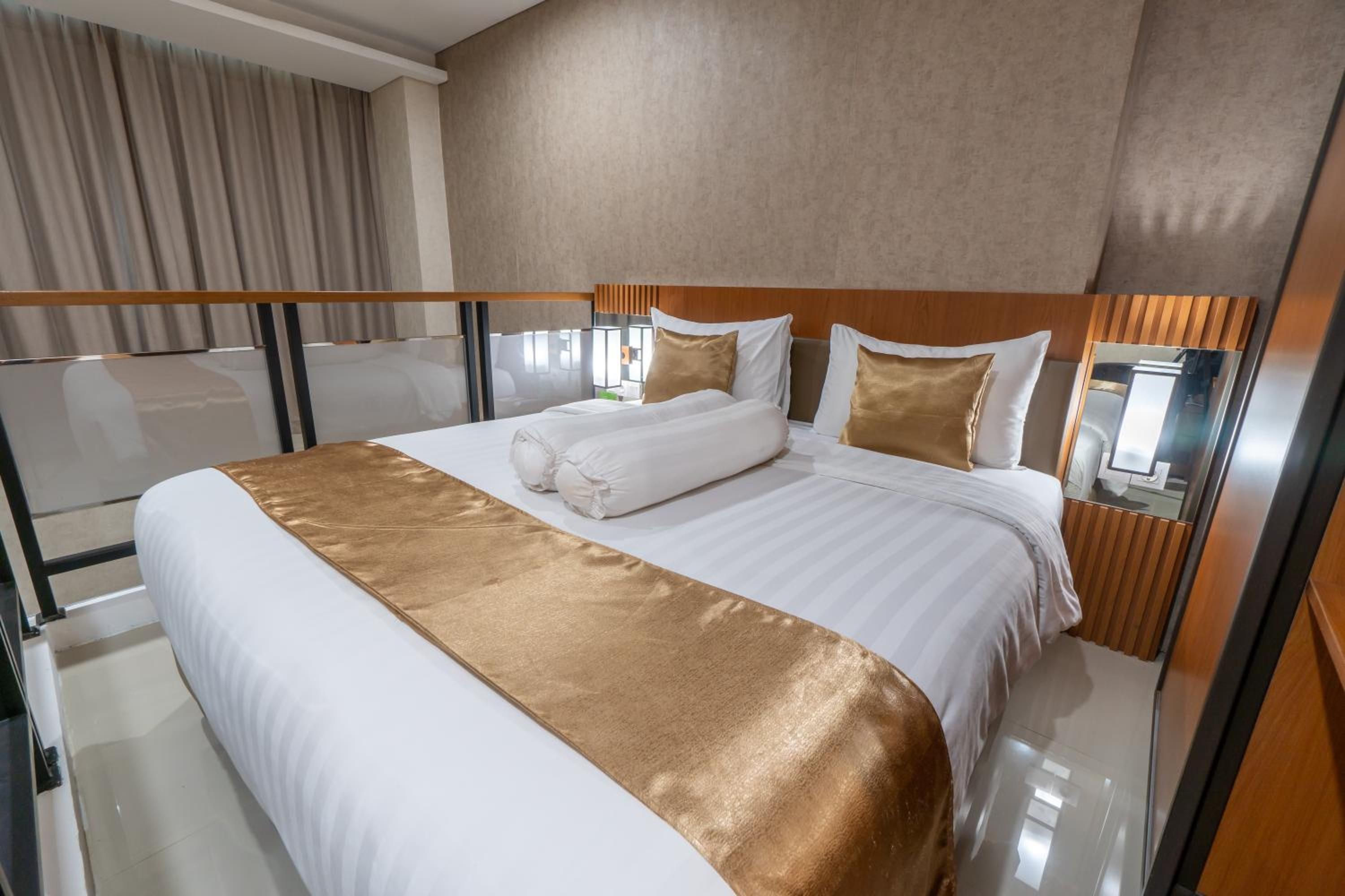A hotel room with a large bed, a wooden headboard, and a view of the city.