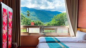 A hotel room with a bed, a view of mountains, and a decorative wall. - Sakura B&B (Ji'an)
