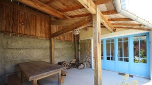 A rustic wooden interior with a bench and a door leading outside. - Henriette, between beach and market (La Brée-les-Bains)