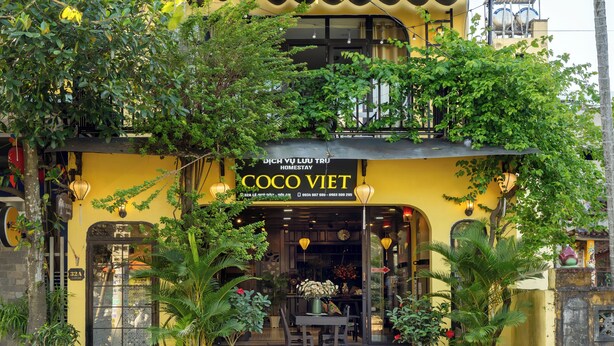 A yellow building with a sign reading "COCO VIET HOMESTAY". - Hoi An Coco Viet Homestay (Da Nang)