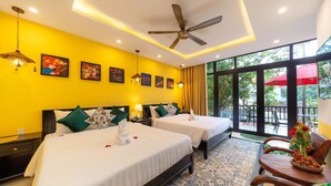 A hotel room with two beds, a ceiling fan, and a balcony with red umbrellas. - Hoi An Coco Viet Homestay (Da Nang)