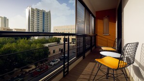 A balcony with a view of a cityscape, featuring modern buildings and a road with cars. - AFAM Residence (Dammam)