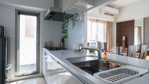 A modern kitchen with a stainless steel sink, a built-in stove, and a window overlooking a balcony.