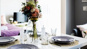 A dining table set with plates, cutlery, and a vase of flowers. - Crystal Exe Nipponbashi St36 (Osaka)