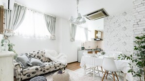 Un salon moderne avec un canapé blanc, une table à manger et un mur en briques.