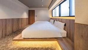 Ein modernes Schlafzimmer mit einem großen Bett, Holzvertäfelung und einem Fenster mit Jalousien.