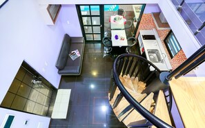 A modern kitchen with a dining area, a staircase, and a seating area.