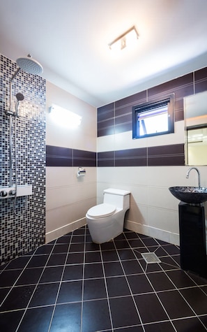 A bathroom with a toilet, bidet, and a sink.