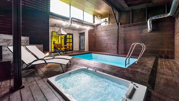 A spa area with a hot tub, wooden flooring, and a pool. - Vista Hill Pool Villa (Gapyeong)