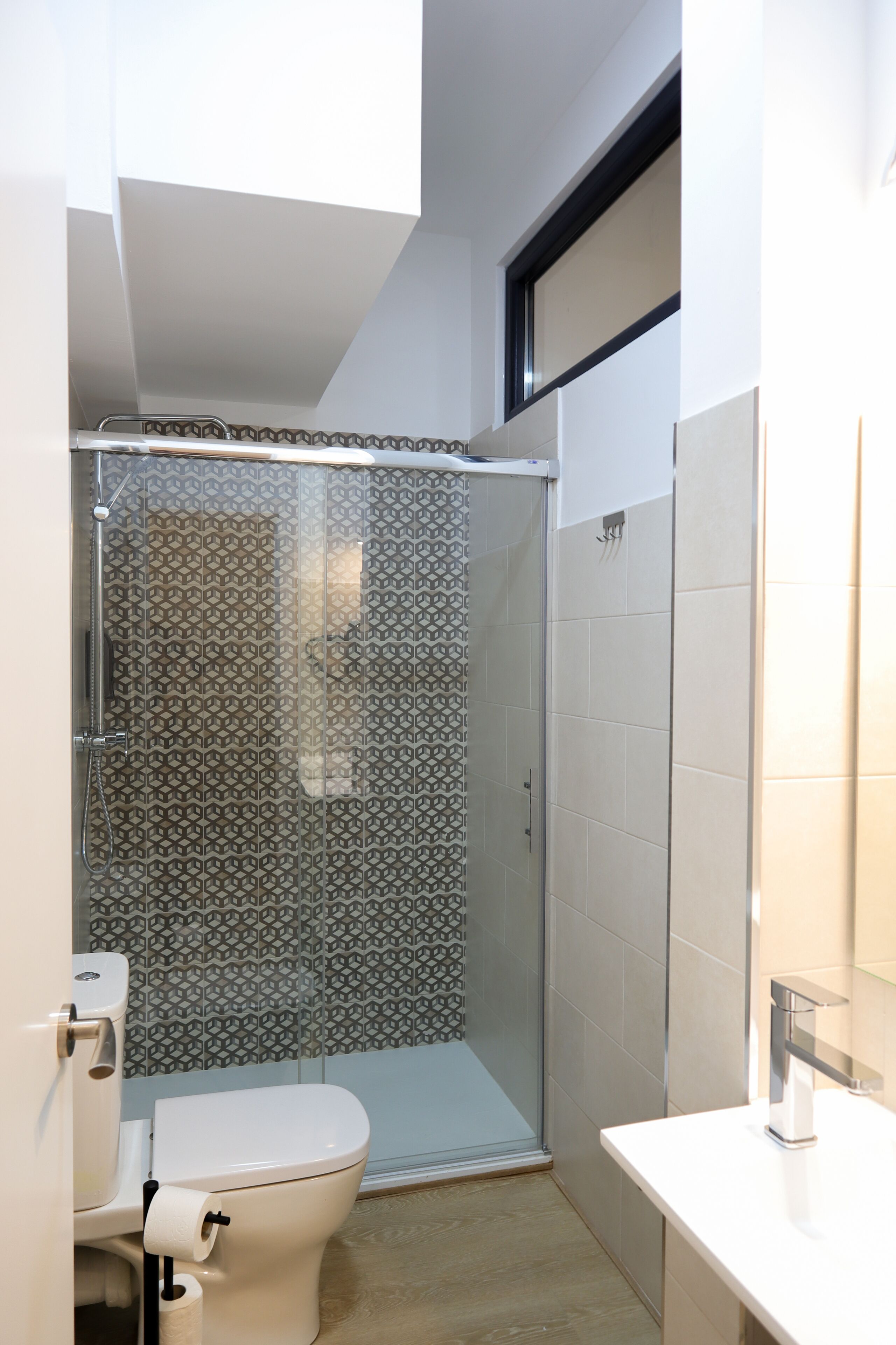 Une salle de bain moderne avec une douche, des toilettes et un lavabo.