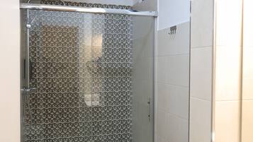 Une salle de bain moderne avec une douche, des toilettes et un lavabo.