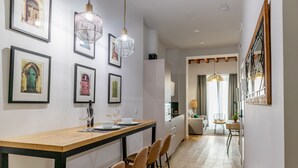Eine moderne Küche mit Holzarbeitsplatte, Barhocker und Pendelleuchten.