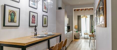 Une cuisine moderne avec un plan de travail en bois, des tabourets de bar et des luminaires suspendus.