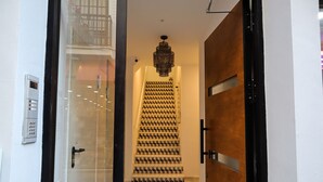 Ein modernes Interieur mit einer Glastür, einer Holztür und einer gestreiften Treppe.