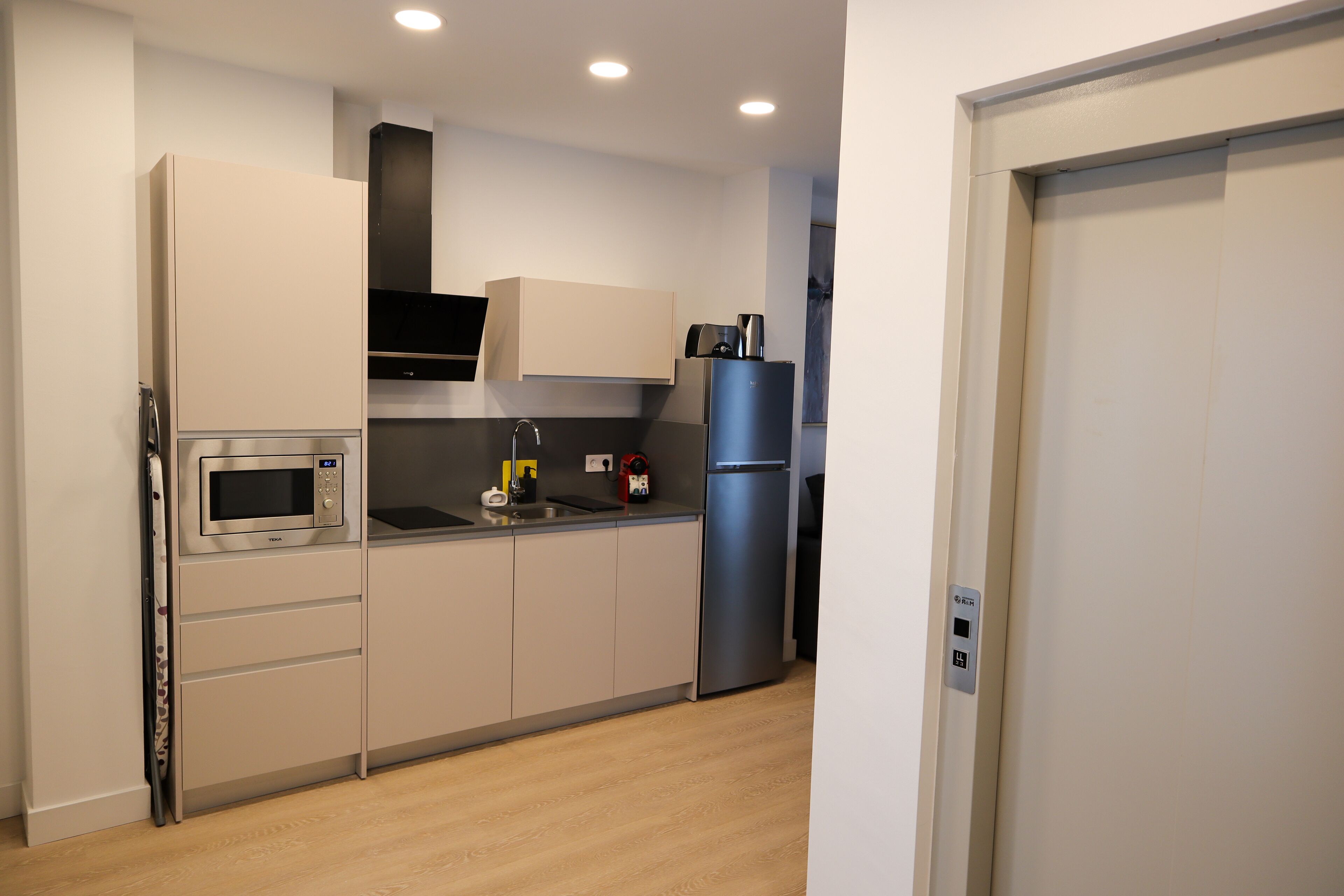 A modern kitchen with a built-in microwave, oven, and refrigerator.