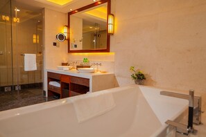 A modern bathroom with a freestanding bathtub, a glass-enclosed shower, and a vanity with two sinks.