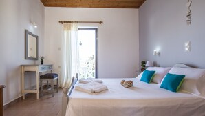 Una camera da letto con un letto, un comodino, una sedia, una finestra con tende e vista all'esterno.