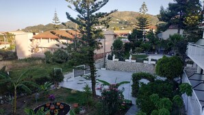 Zona residenziale con giardino, un muro in pietra e vista su una montagna.