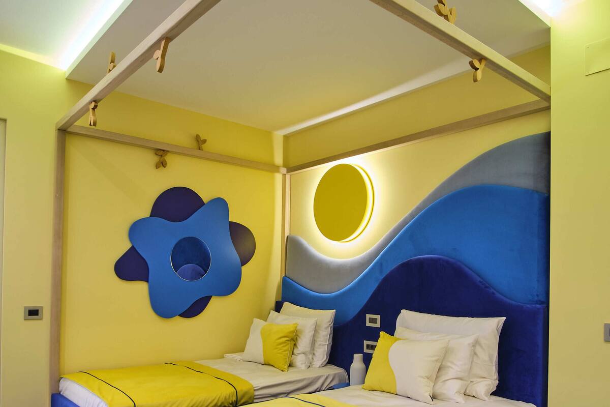A bedroom with a large bed, two bedside tables, and a unique ceiling design.