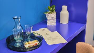 A reception desk with a tray holding a glass vase, two glasses, a plant, a white vase, and a menu.