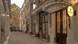 Rua estreita com lojas e um anúncio para o Vilacrosse Boutique Inn.
