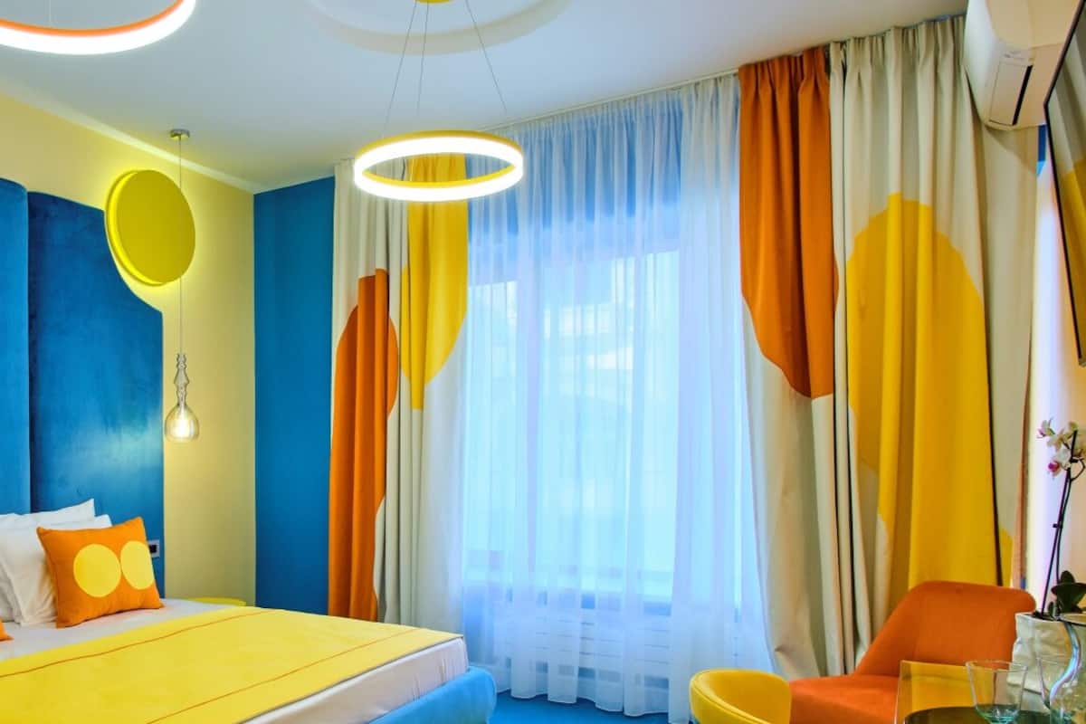 A modern hotel room with a bed, a chair, and a table.