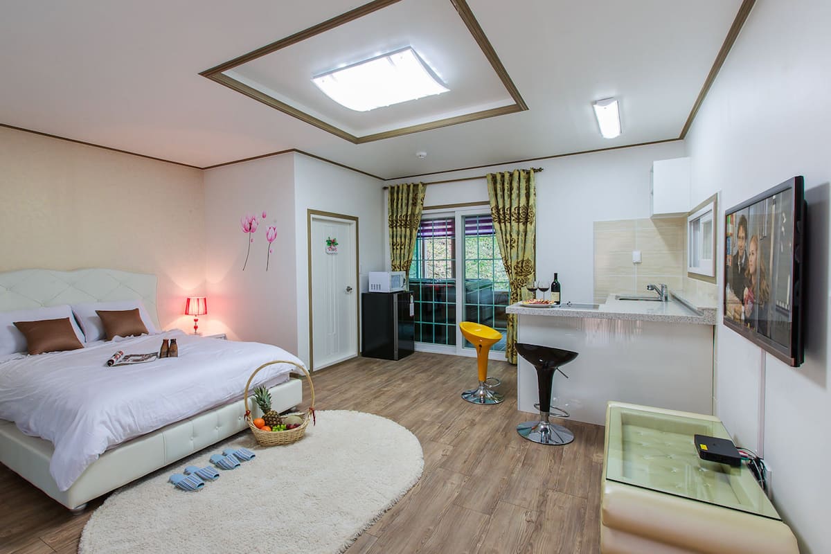 A bedroom with a bed, bedside table, lamp, and a fruit basket.