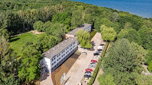 An aerial view of a building with a parking lot and a view of the sea. - Aqua House (Sopot)
