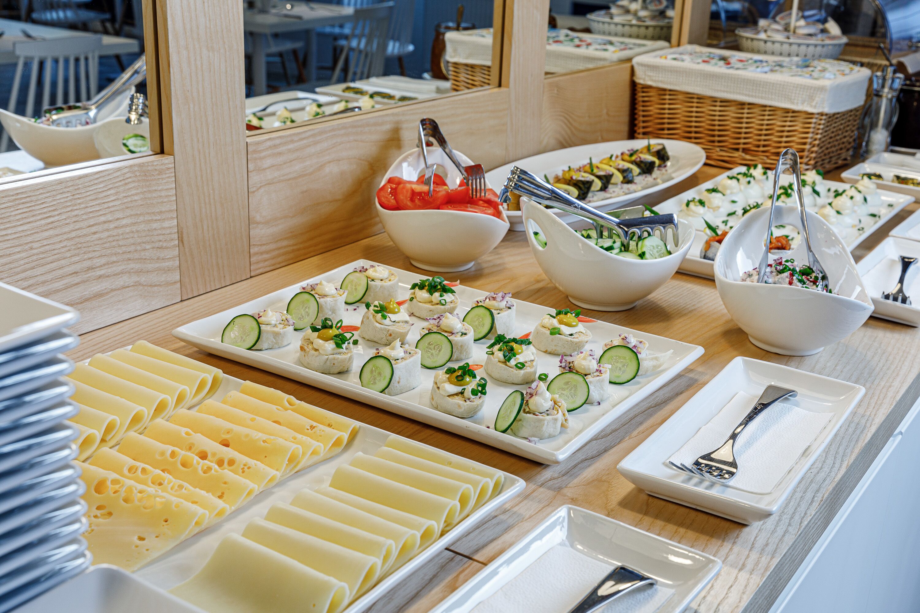 A buffet table with various food items and utensils.