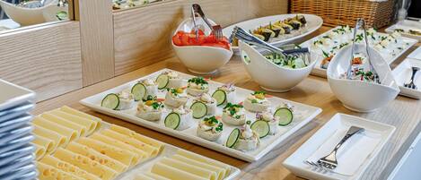 A buffet table with various food items and utensils.