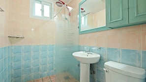 A bathroom with a white sink, a toilet, and a shower with a red handle. - Lake and Pine Spa Pension (Pocheon)