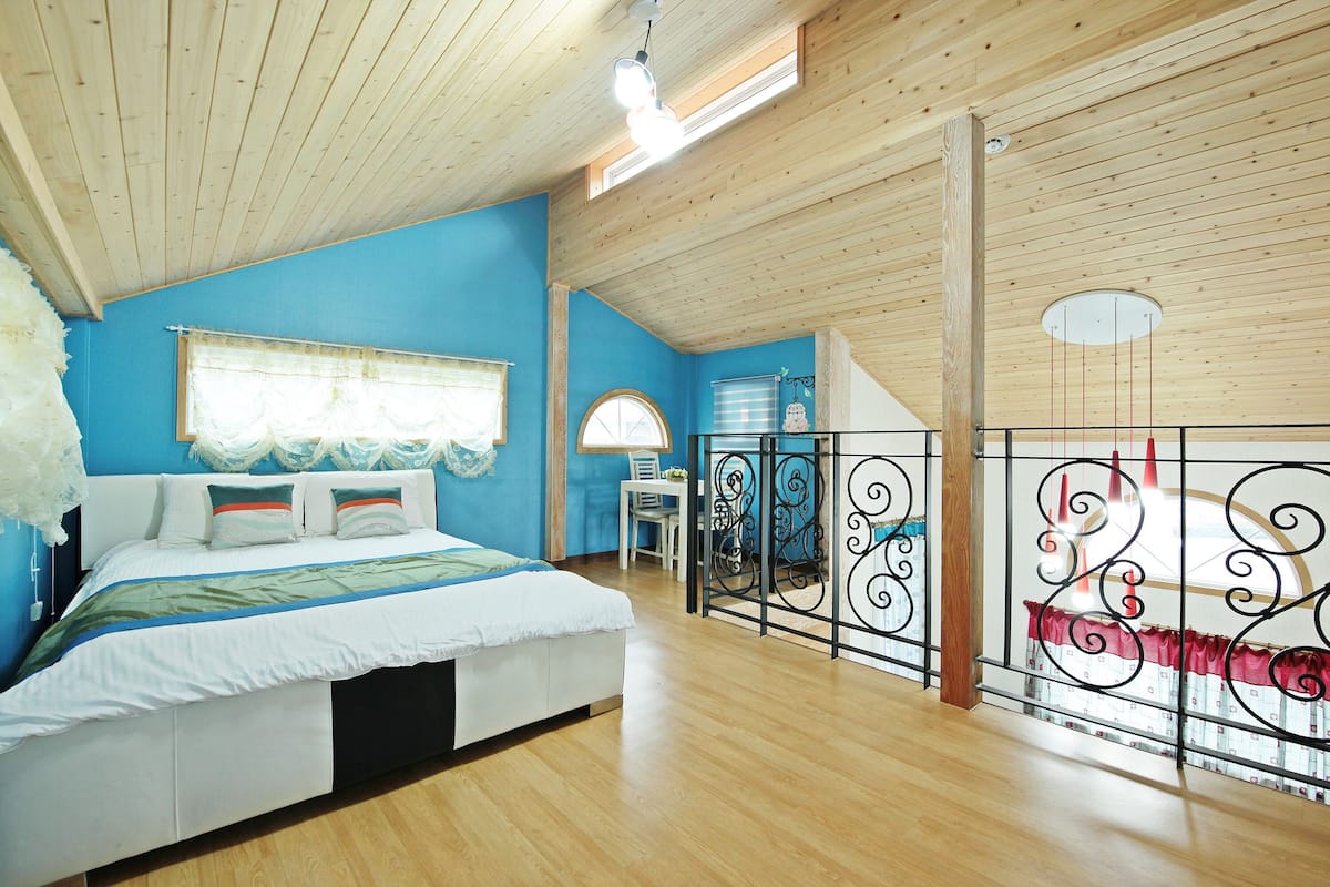 Ein Schlafzimmer mit Bett, Schreibtisch und Fenster.