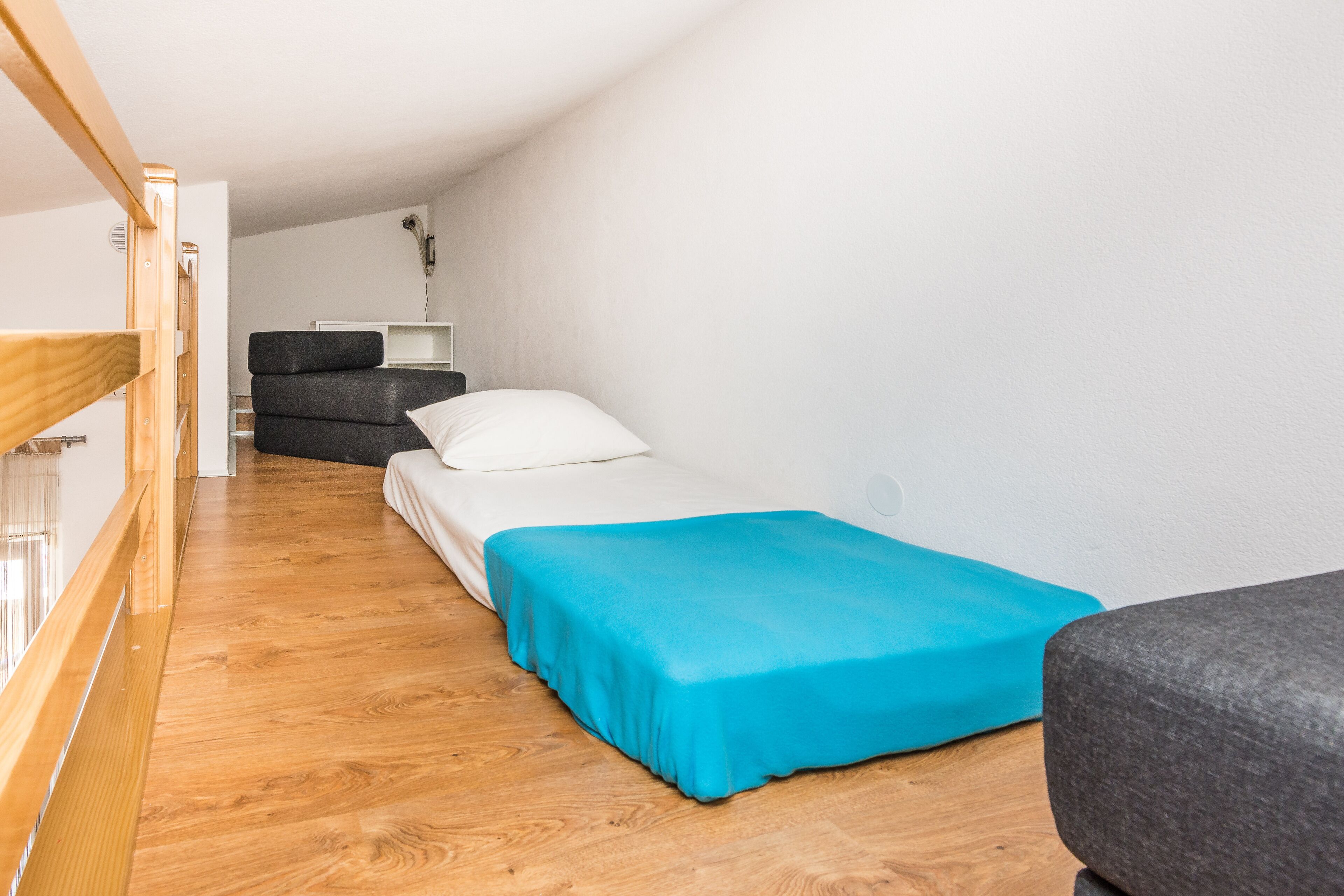 Une petite pièce, de taille modeste, comprenant un lit, un bureau et une chaise.