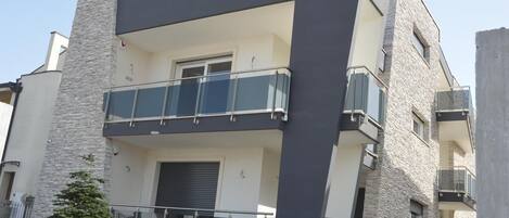 A modern two-story building with a balcony on the second floor.