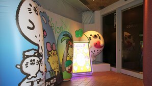 A hotel lobby with a colorful wall featuring cartoon characters and a neon sign. - Hotel GOMAX - Adults Only (Yokohama)