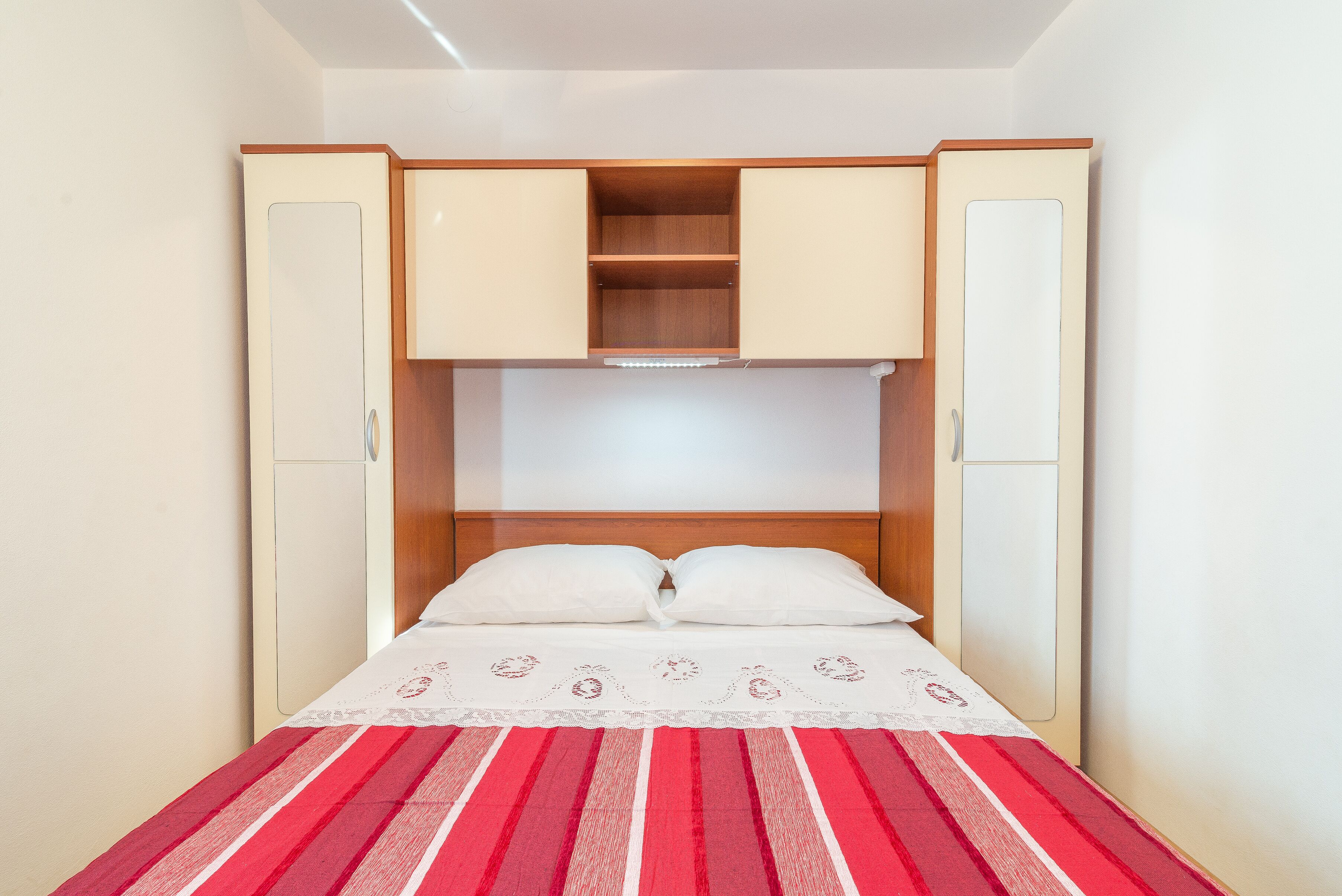 Une chambre à coucher avec un lit, deux armoires et une tête de lit en bois.