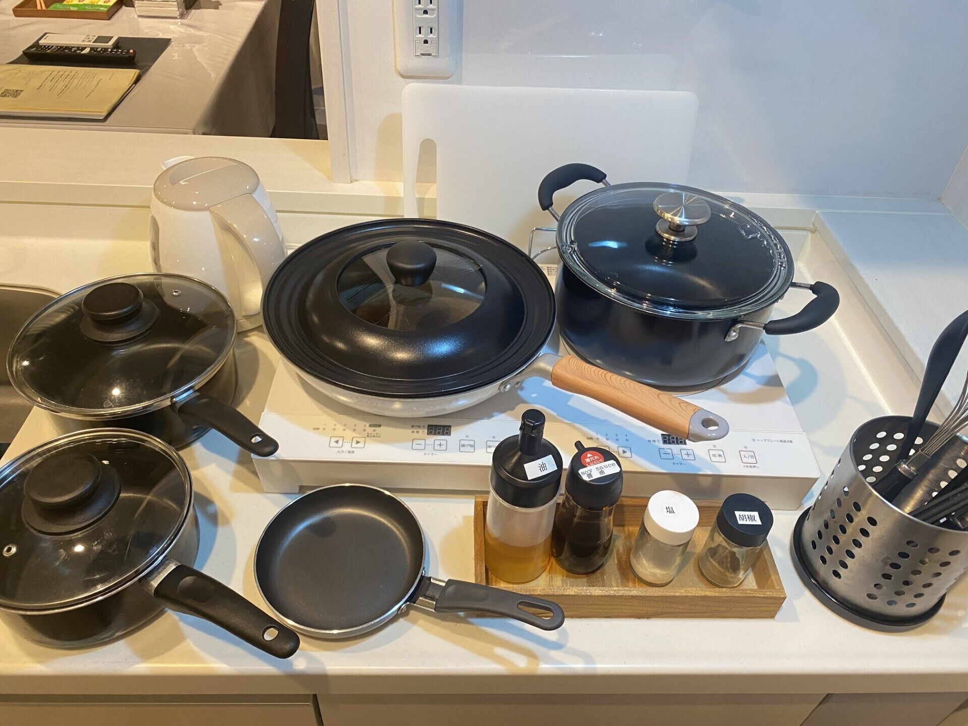 Een keuken met verschillende kookpotten en -pannen, een fornuis en een vergiet.