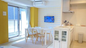 Una cocina moderna con comedor, un televisor montado en la pared y vistas al exterior.
