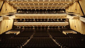 Un teatro con butacas escalonadas, varios niveles y un diseño moderno.
