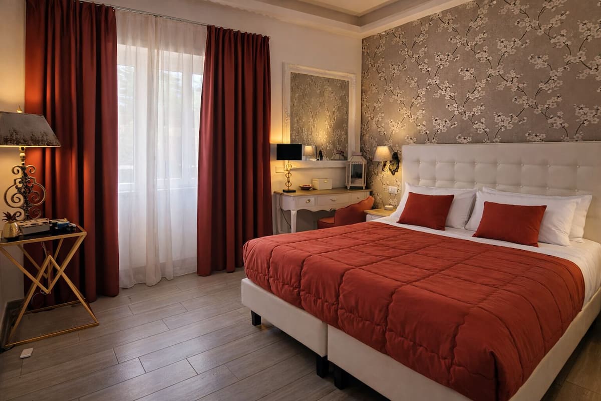 A bedroom with a large bed, a desk, and a chair.
